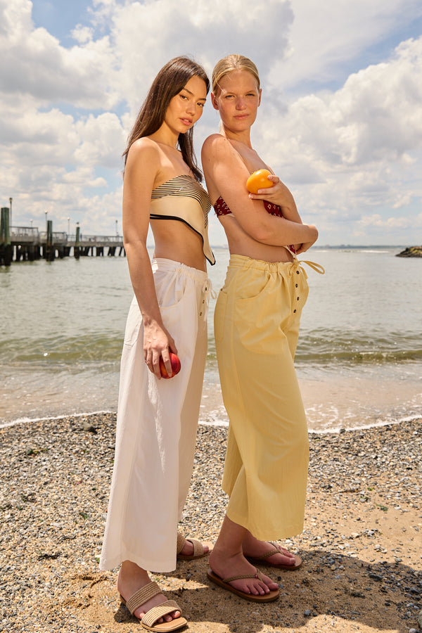 Two women standing on the beach wearing Du & Berry cotton palazzo pants in yellow and white with casual tops