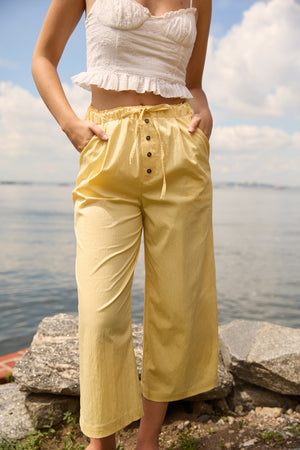 Du & Berry Cotton Palazzo Pants in Yellow with button details and drawstring waist worn by model outdoors