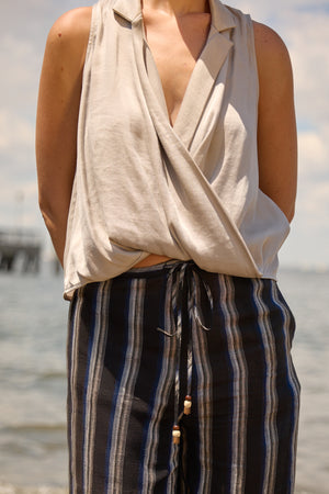 Du & Berry Grey Twist Collared Top sleeveless with a draped front worn outdoors near water