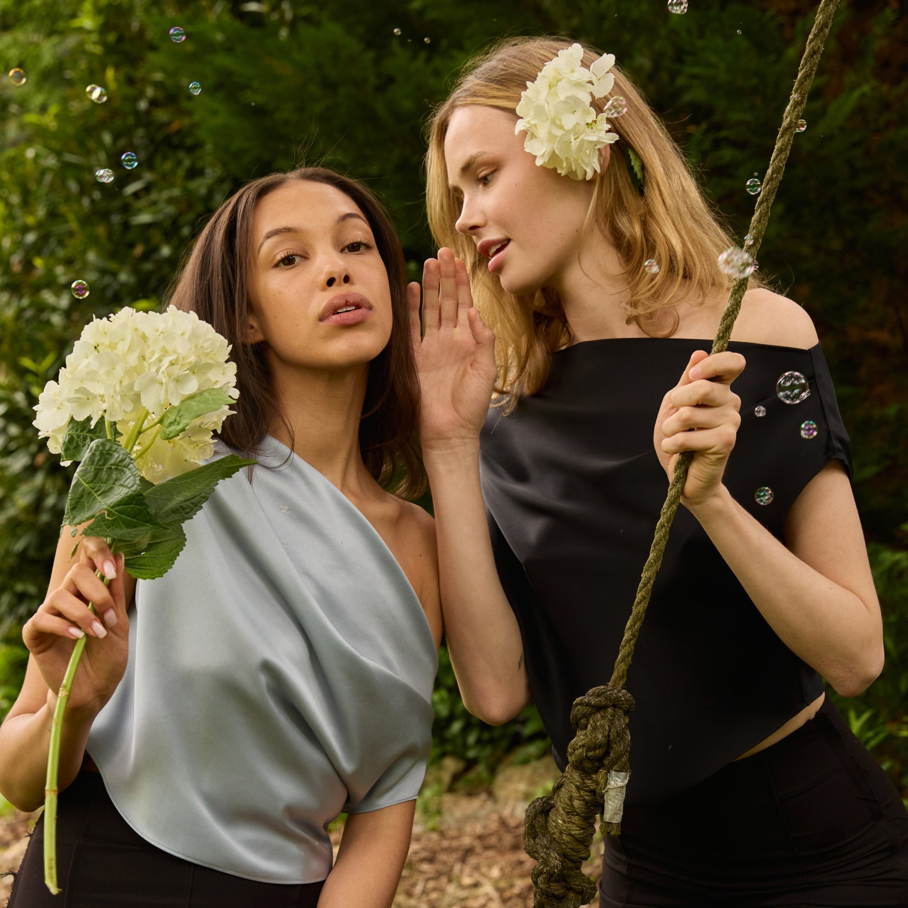 Two women dressed elegantly with flowers in hair and hand learning how to dress when invitation has no dress code