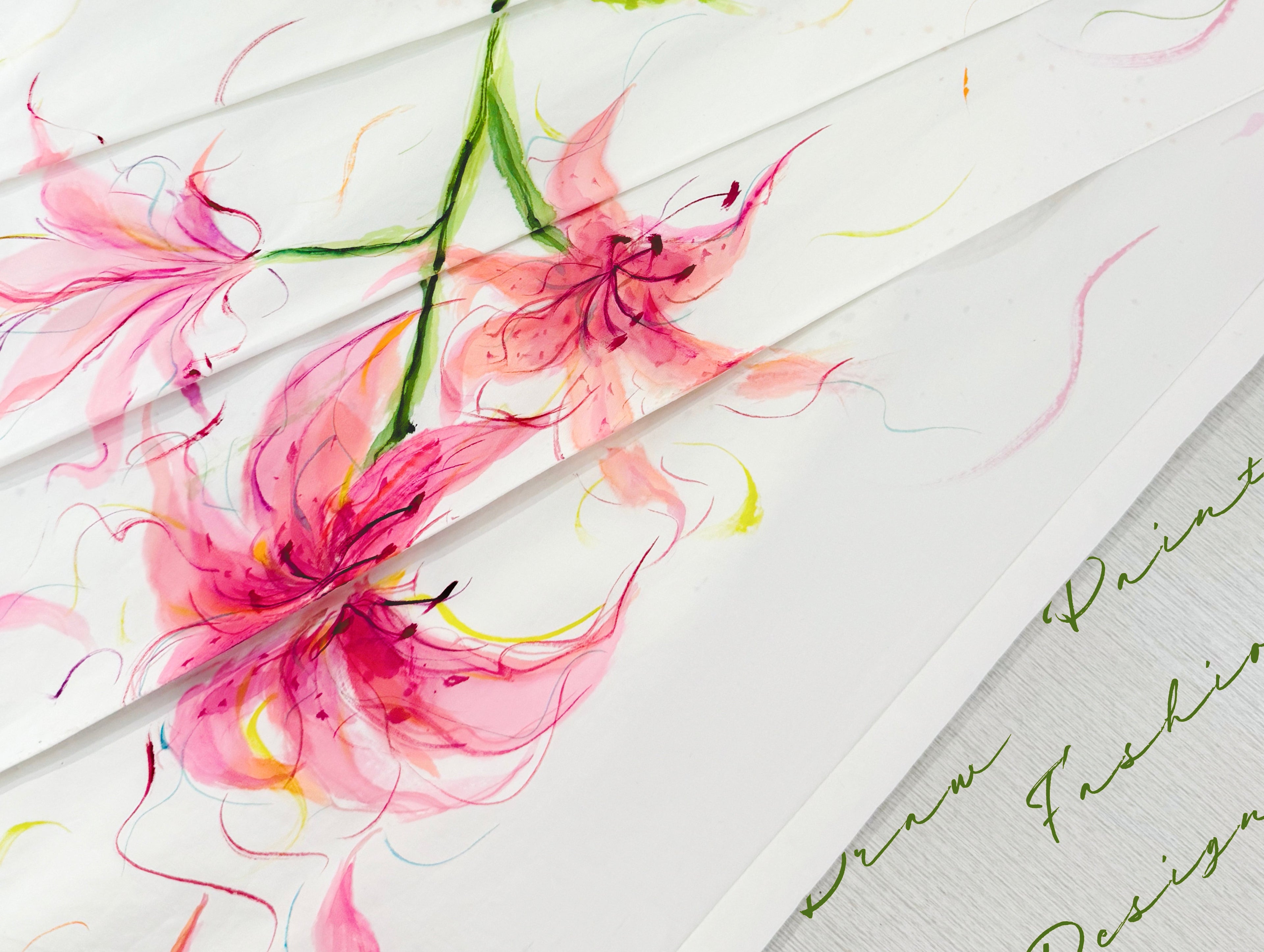 Close-up of apparel inspired by fine art featuring delicate pink floral watercolor designs on white fabric