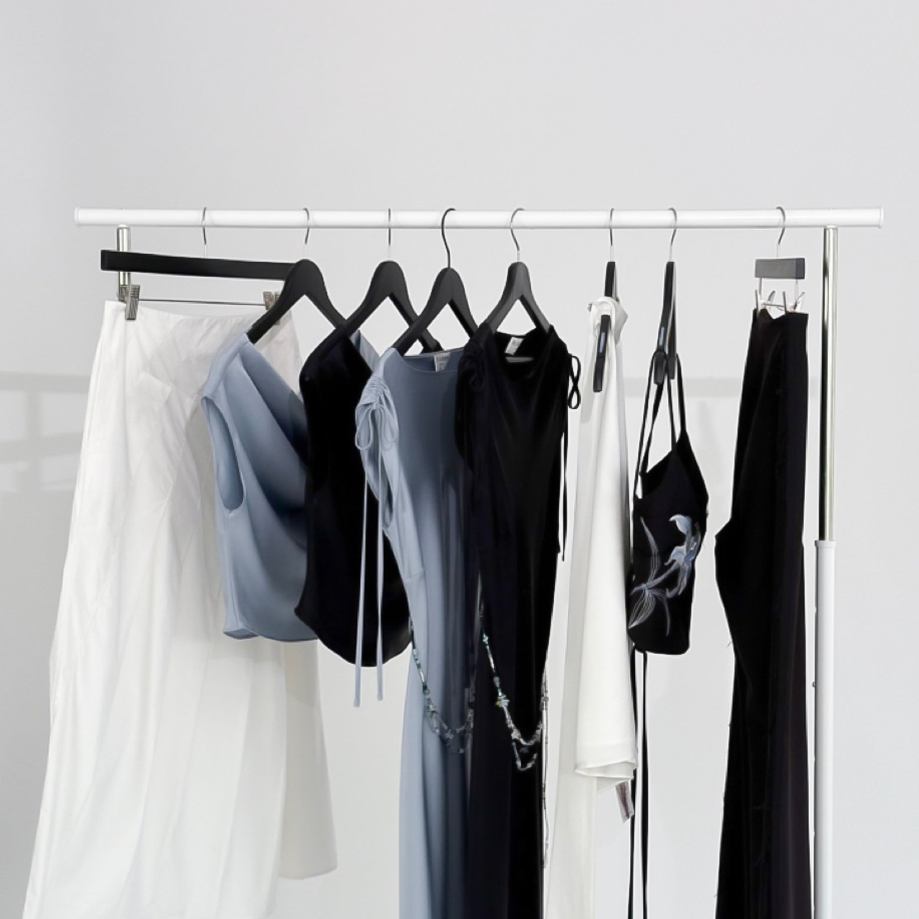 New collection 25SS Midnight Bloom featuring elegant black white and blue dresses and tops on a clothing rack