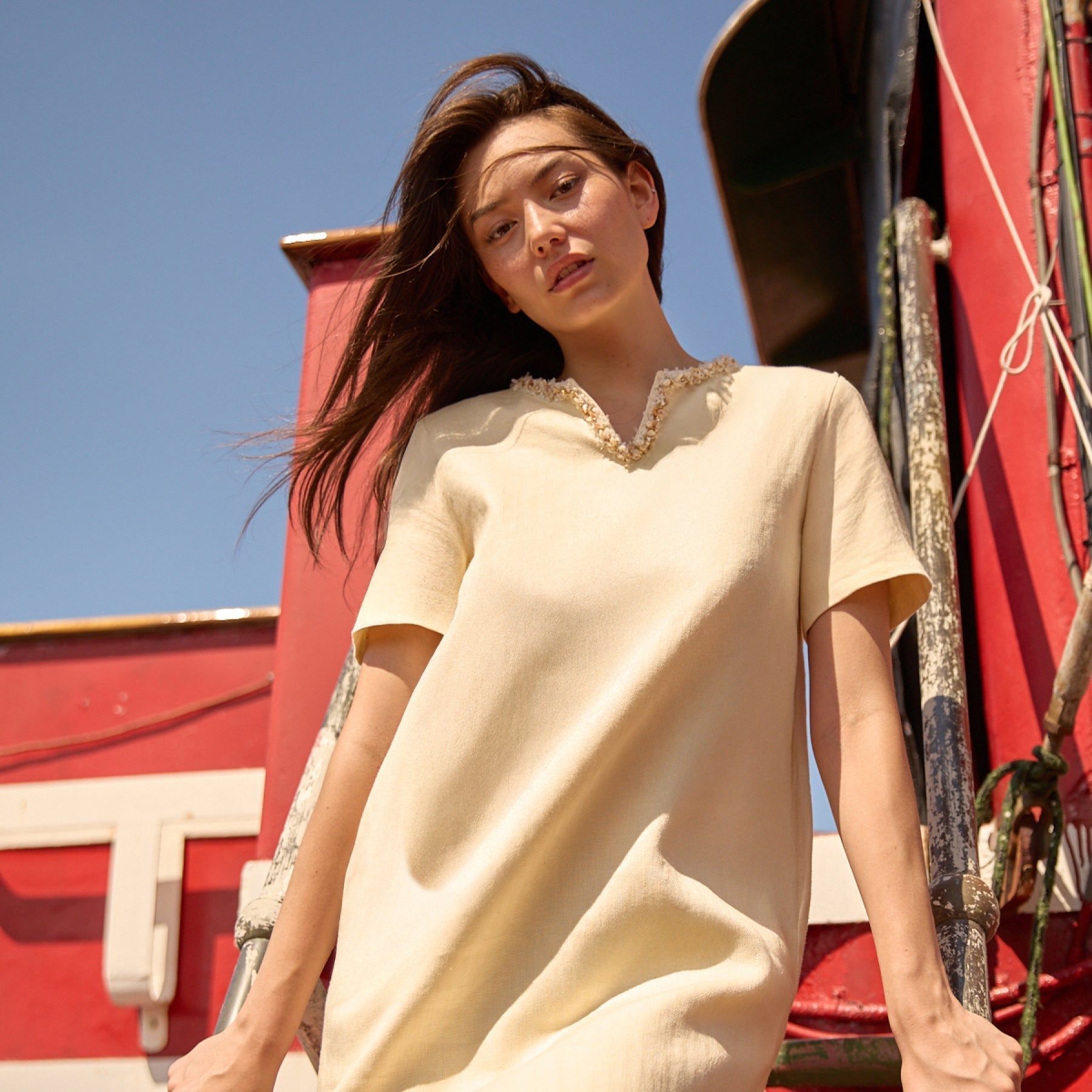 Model wearing a beige dress from the Du & Berry's New Collection 25SS standing outdoors by a red structure