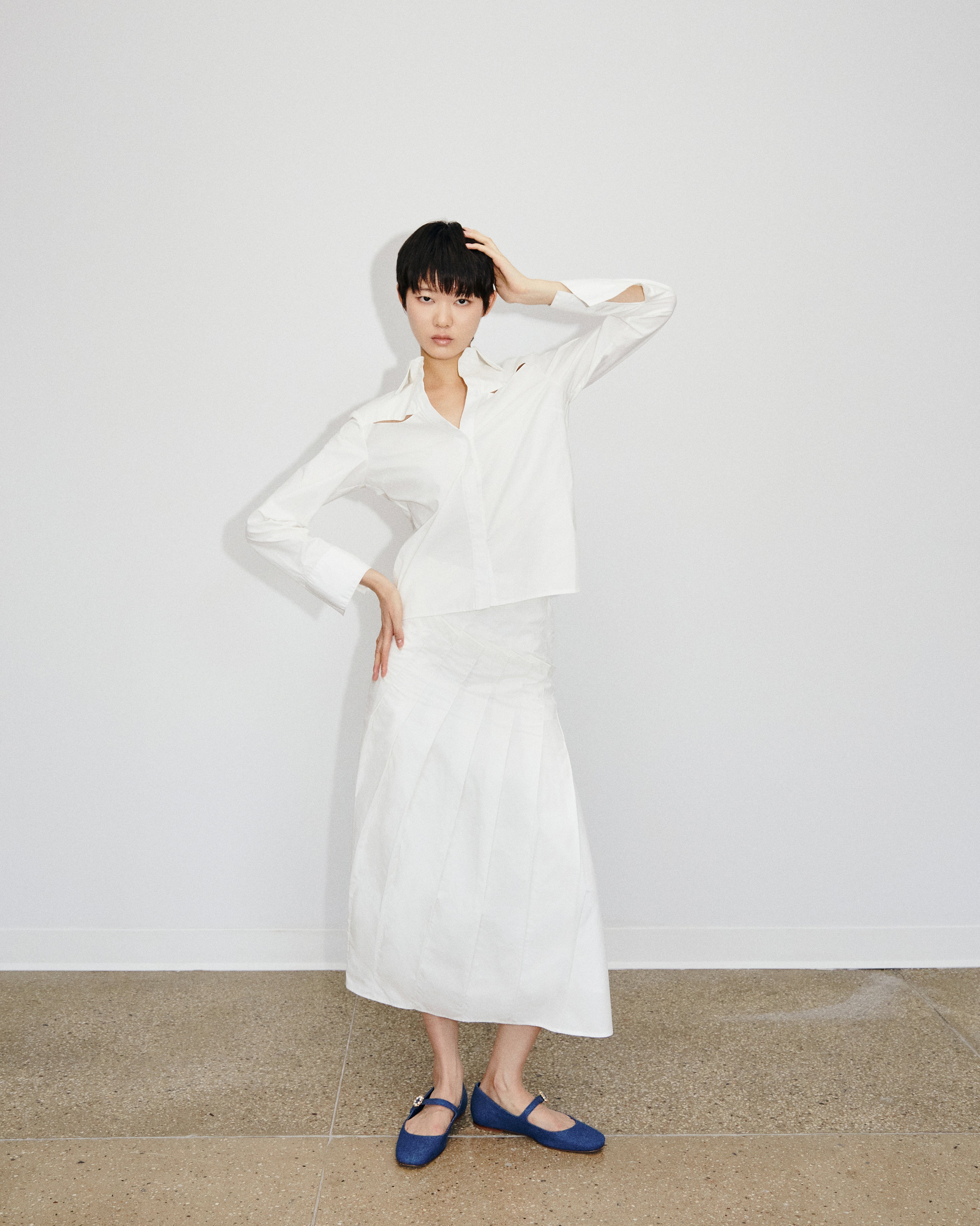 Front image of model wearing Du & Berry Du Cotton Poplin Button up white skirt and shirt showcasing the hand pleated details