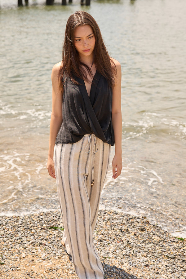 Du & Berry wide leg beach pants for women in beige with stripes worn by model at the shore