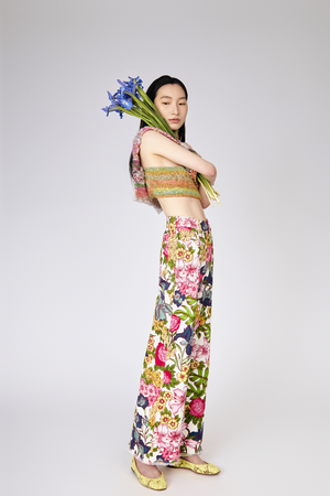 Full side view of model wearing One of a Kind cropped knit sweater top with Floral Symphony Jeans holding flowers