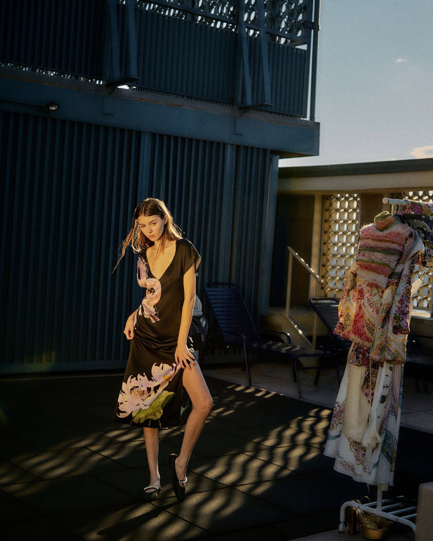 Model on city rooftop wearing the Du & Berry Loong Warrioress black silk midi dress with mythological placement print