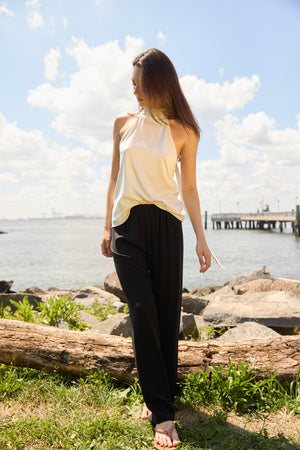 Woman wearing Du & Berry Black Comfort Straight Pants outdoors near water on a sunny day