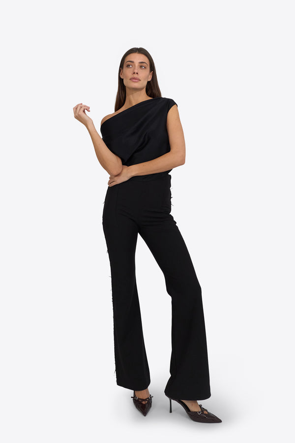 Du & Berry black flared pants worn by woman with one-shoulder black top and heels