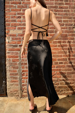 Du & Berry Black Jacquard Midi Skirt with side slit worn by model against brick wall