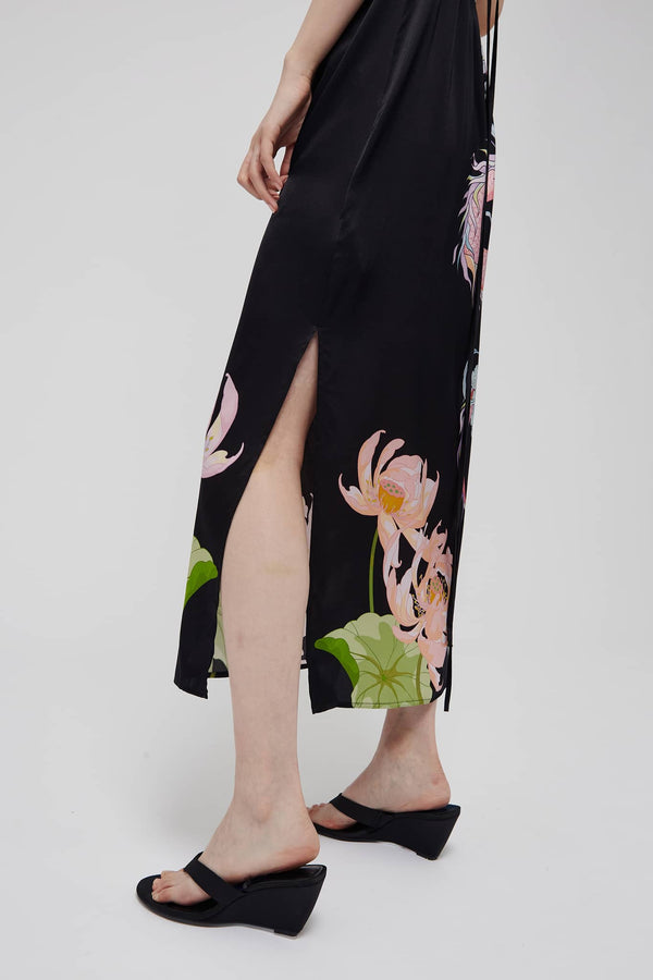 Side view: black silk open-back midi dress with floral print and side slit detail