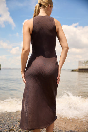 Back view of woman wearing a Brown Linen Side Split Maxi dress by Du and Berry at the beach