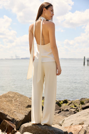 Woman wearing Du & Berry Cream Comfort Straight Pants standing by the rocky shore with a light sleeveless top