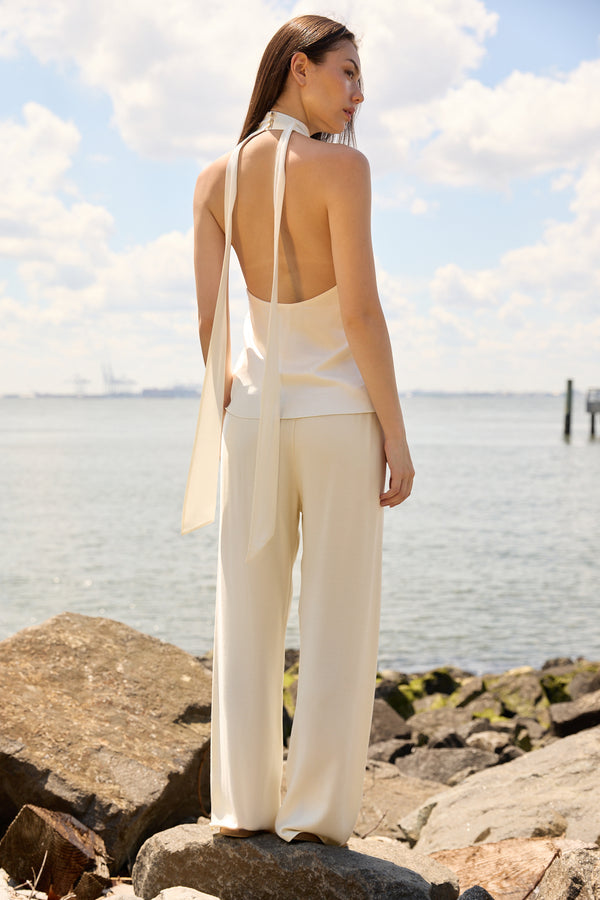 Woman wearing Du & Berry Cream Comfort Straight Pants standing by the rocky shore with a light sleeveless top