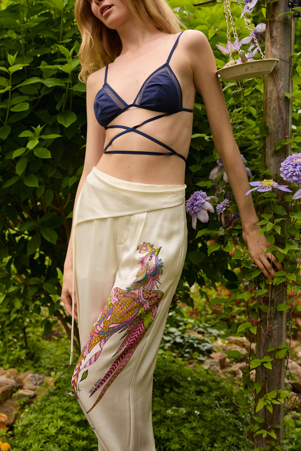 Du & Berry Phoenix Belted Silk Trousers in cream with colorful phoenix print worn by model outdoors