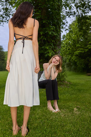 Du & Berry Pleated Cotton Poplin Midi Skirt in white worn outdoors with greenery background