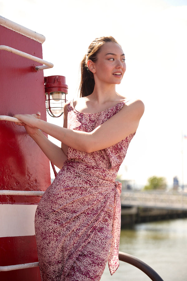 Woman wearing Du & Berry convertible silk wrap dress in pink floral pattern by the waterfront