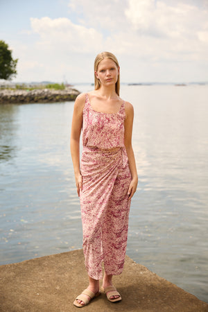Du & Berry convertible silk wrap dress in pink floral pattern worn by model near water