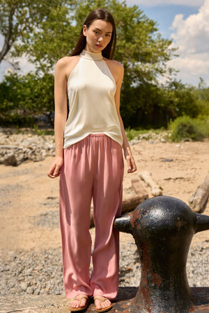 Du and Berry dusty rose straight pants worn by a model with a sleeveless cream top outdoors