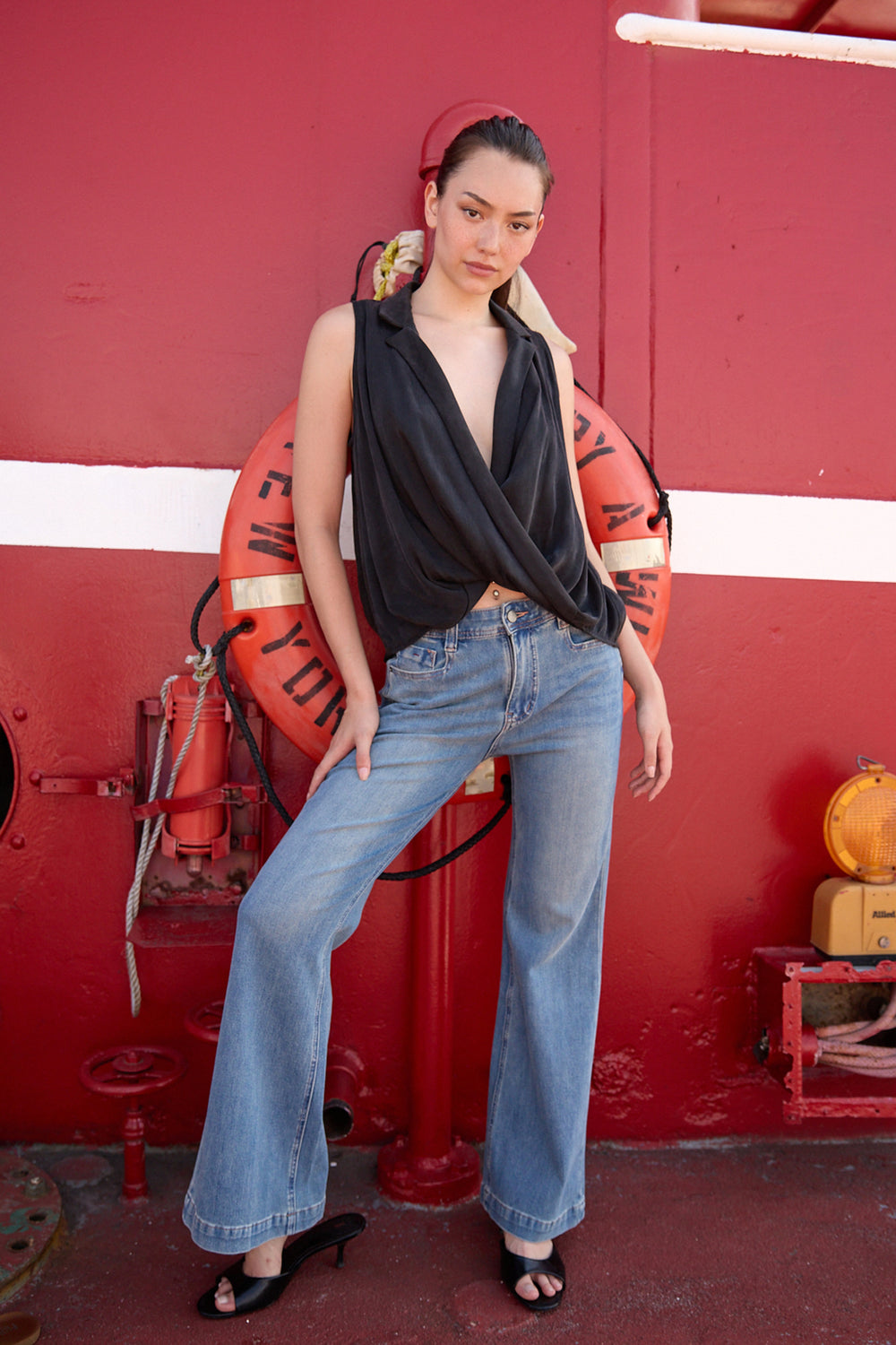 Woman wearing Du & Berry light blue flared denim jeans paired with a black sleeveless top