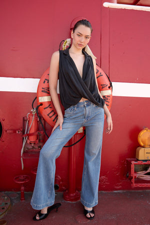 Woman wearing Du & Berry light blue flared denim jeans paired with a black sleeveless top