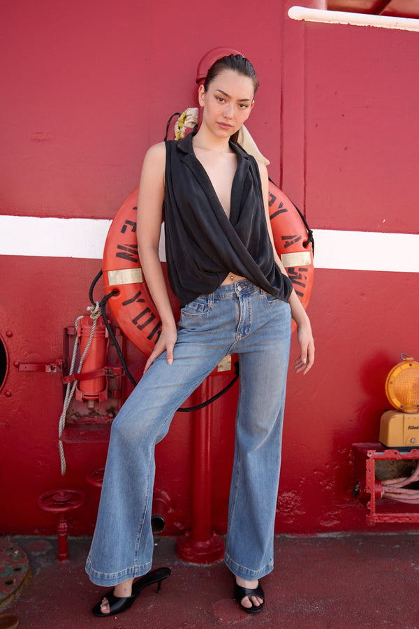 Woman wearing Du & Berry light blue flared denim jeans paired with a black sleeveless top
