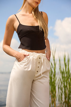 Du & Berry white cotton palazzo pants with button details worn by woman outdoors