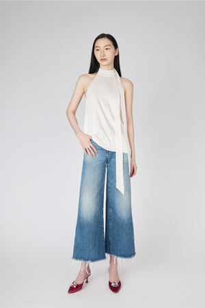 Du & Berry white halter blouse paired with wide-leg faded blue jeans and red heels