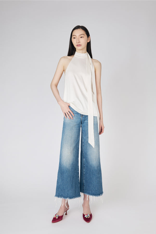 Du & Berry white halter blouse paired with wide-leg faded blue jeans and red heels