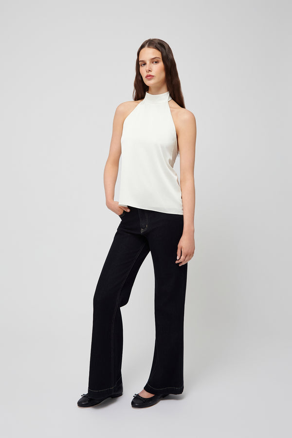 Front view: white halter blouse in soft fabric paired with black wide-leg pants